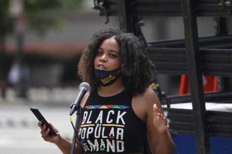 Woman speaks at microphone during a protest